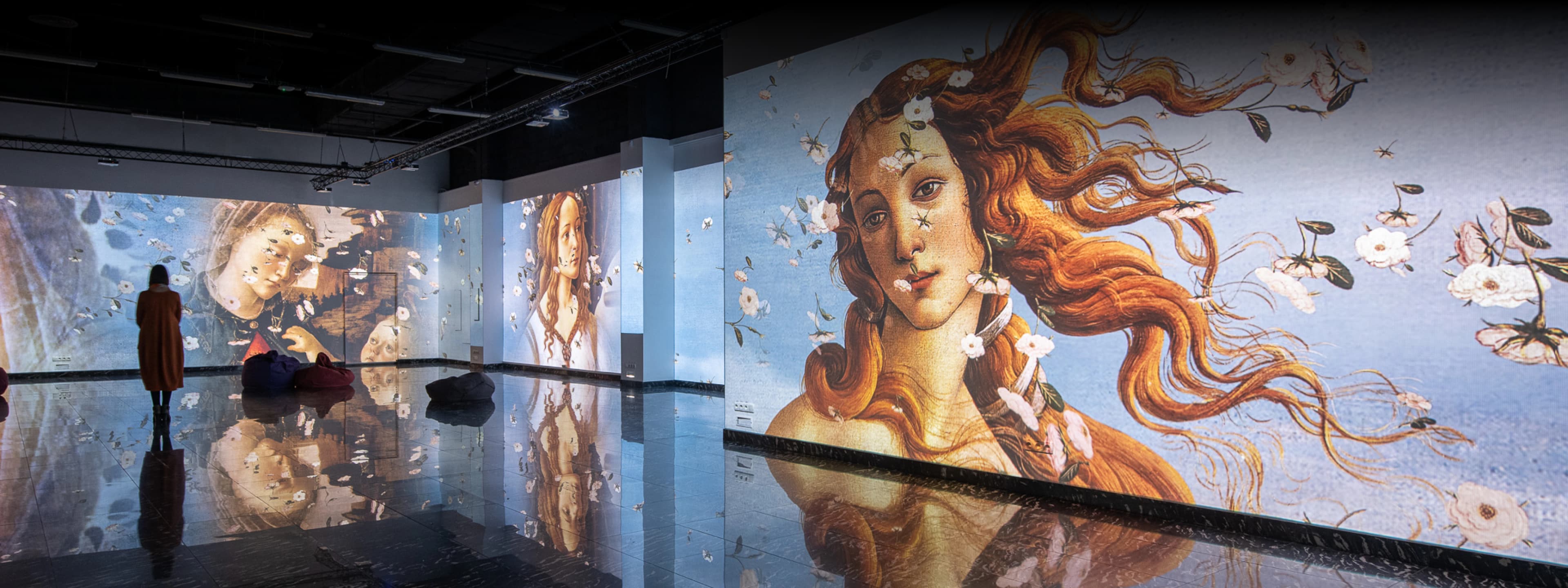 A woman looking at classical art in a digital art gallery powered by a Screenberry media server